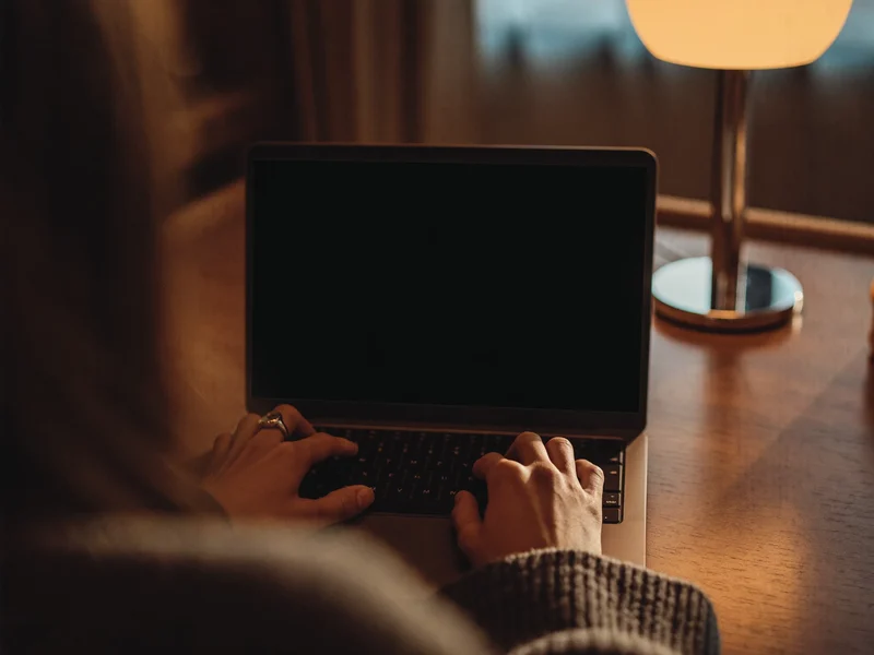 Débutant qui tape du code sur un portable, vu par-dessus l'épaule