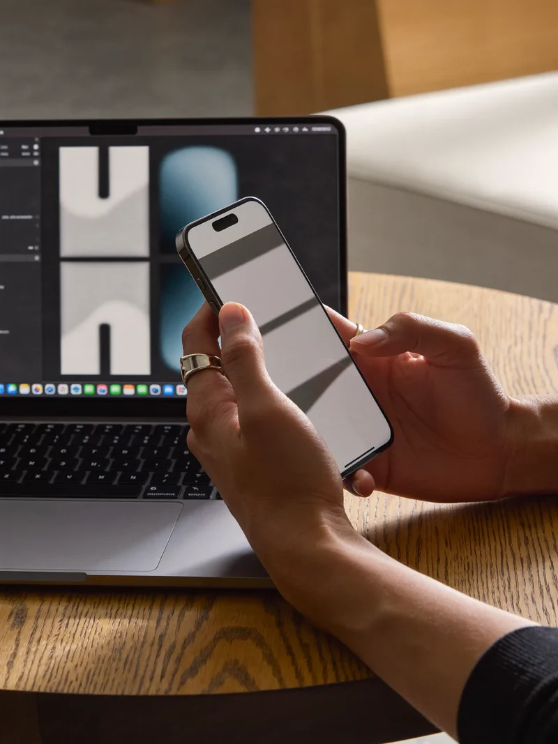 Mains tenant un smartphone à côté d'un ordinateur pour tester un prototype