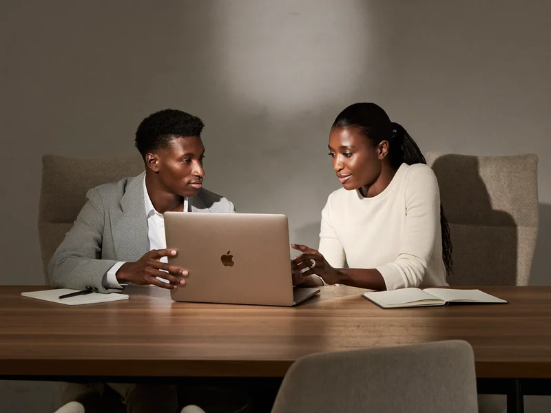 Mentor et apprenant côte à côte devant un même ordinateur portable